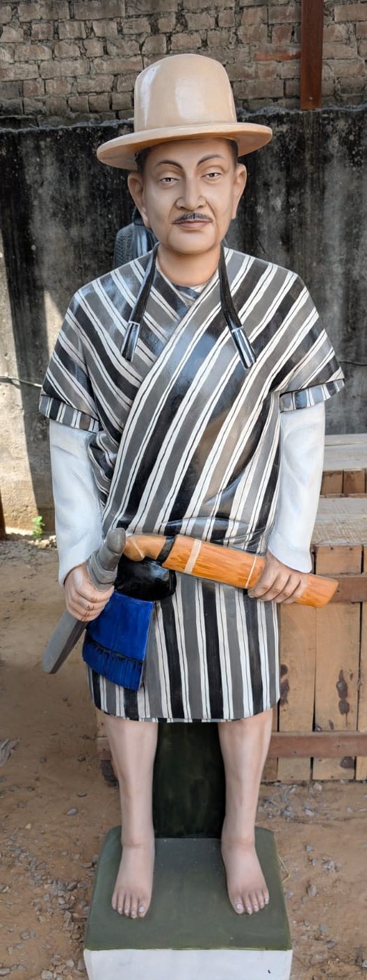 Painted statue of man in striped traditional dress with hat